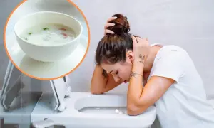 Kobieta z zatruciem pokarmowym pochyla się nad toaletą. Obok miseczka z lekkostrawną zupą, która może pomóc.