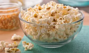 Misternie ułożony popcorn w szklanej misce. Czy popcorn jest zdrowy? To zależy od sposobu przygotowania, ale sam w sobie jest dobrym źródłem błonnika.