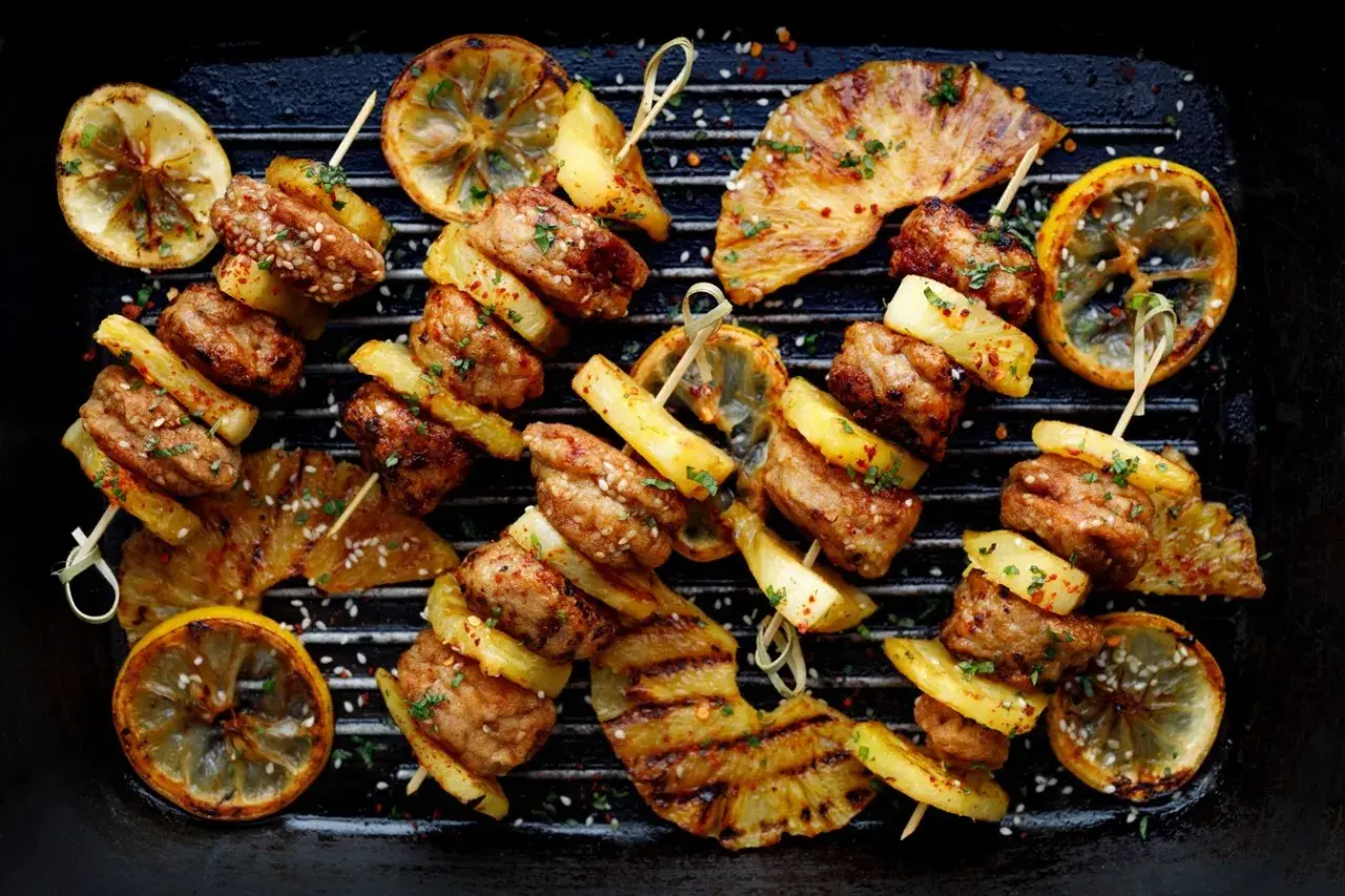 Szukasz odpowiedzi na pytanie: czy grill jest zdrowy? Oto apetyczne szaszłyki z mięsa i ananasa z grillowaną cytryną, które mogą być częścią zdrowej diety.