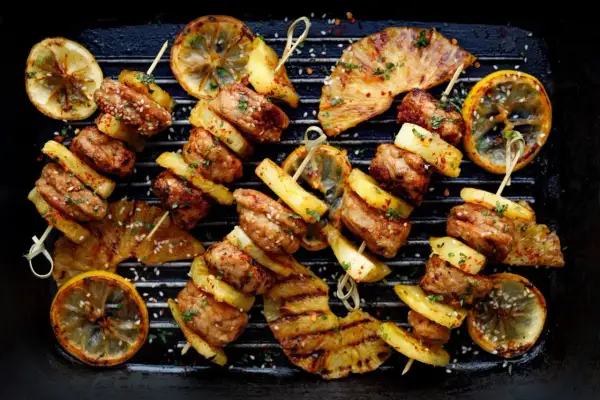 Szukasz odpowiedzi na pytanie: czy grill jest zdrowy? Oto apetyczne szaszłyki z mięsa i ananasa z grillowaną cytryną, które mogą być częścią zdrowej diety.