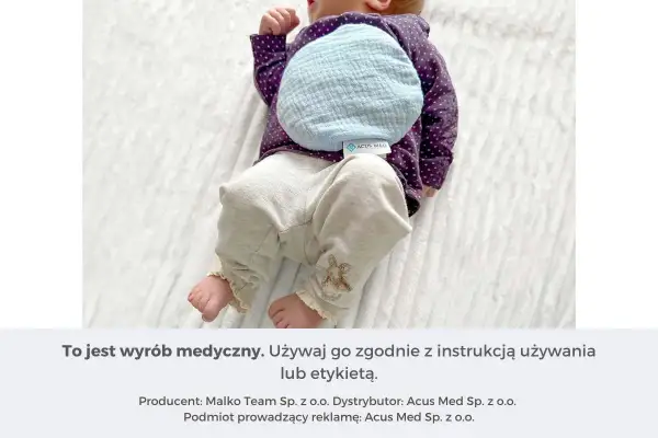 Niemowlę z termoforem z pestek wiśni na brzuszku. Ciepło dla maluszka.
